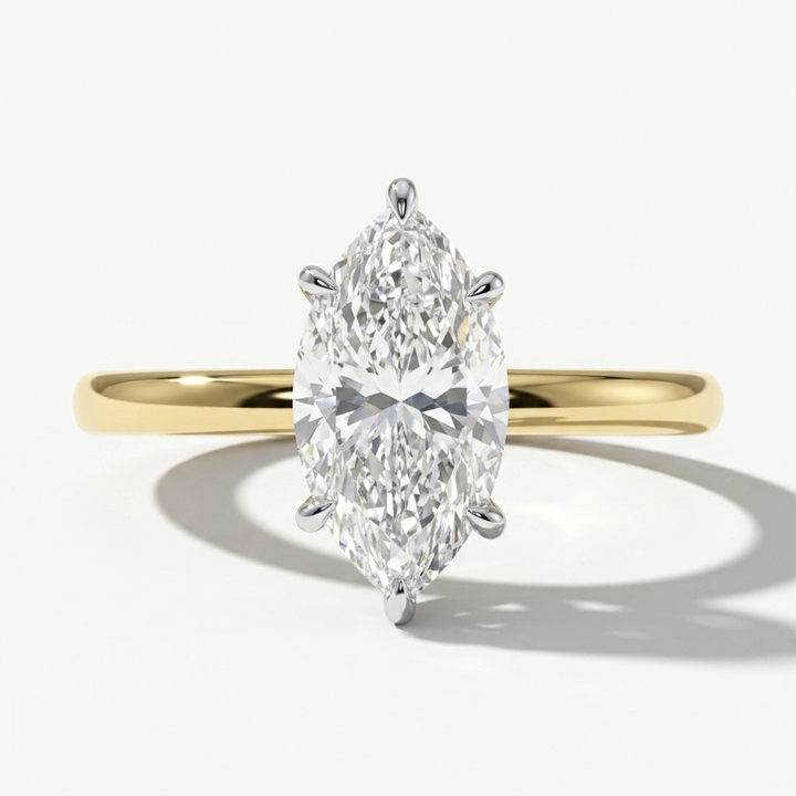 A yellow gold ring with a large marquise-cut diamond center stone, shown on a clean white background with a soft shadow.