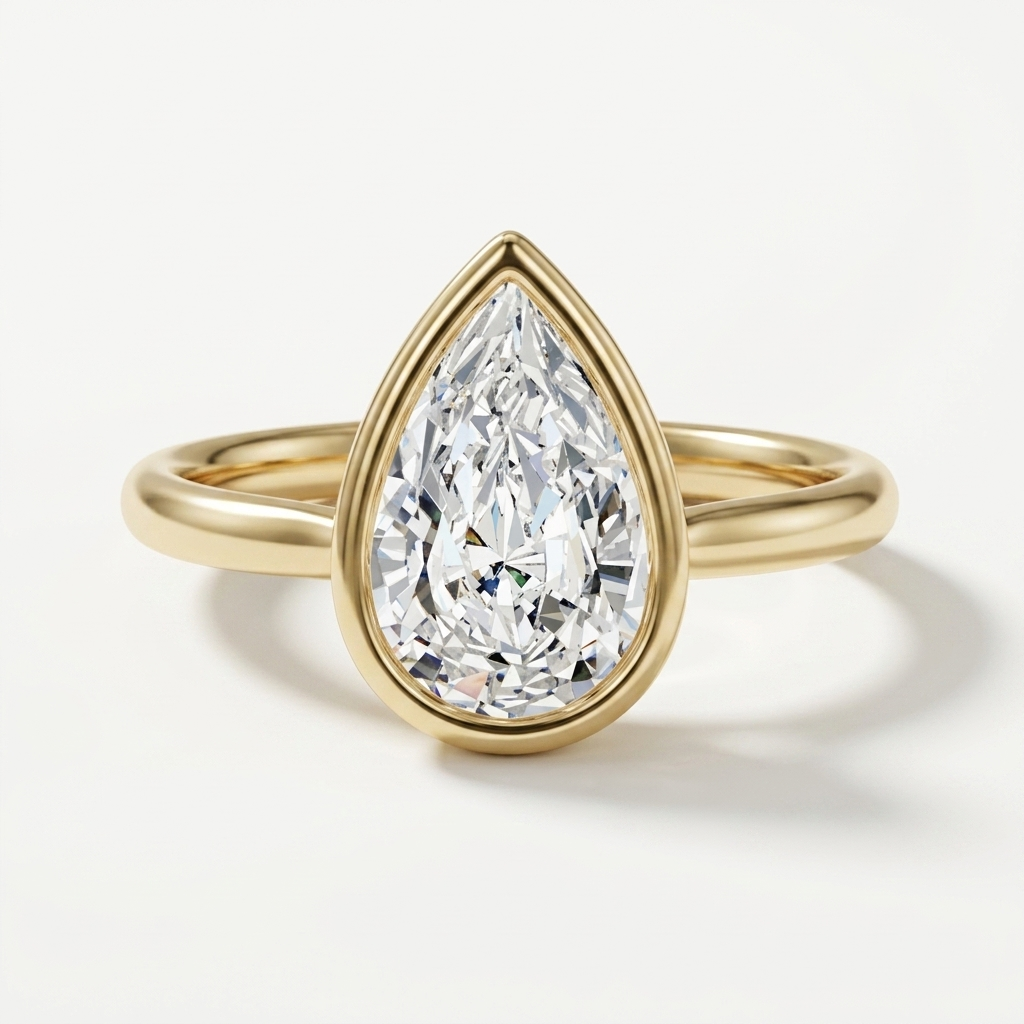 A pear-cut diamond engagement ring in a yellow gold setting and band, shown on a clean white background.