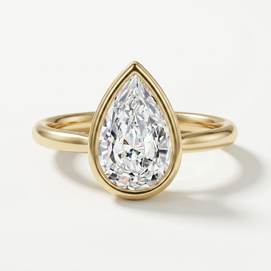A pear-cut diamond engagement ring in a yellow gold setting and band, shown on a clean white background.