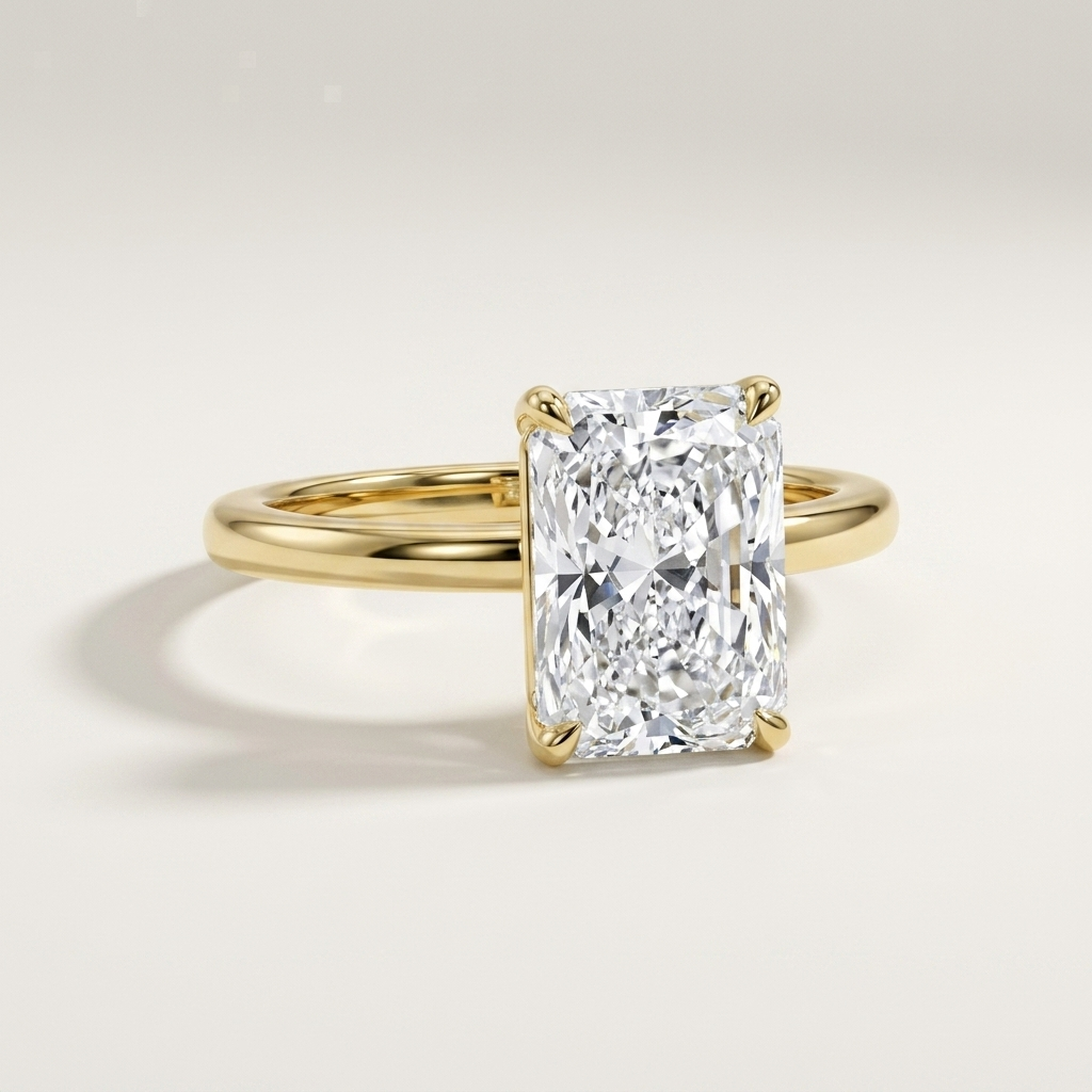 An elegant yellow gold ring featuring a large rectangular radiant-cut diamond solitaire, set against a clean, light beige background.