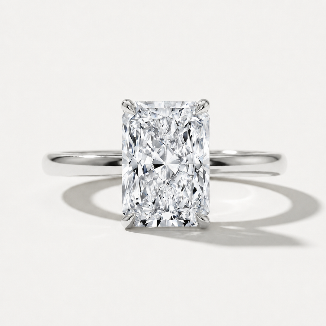 A radiant cut diamond engagement ring with a polished white gold band, centered on a clean white background with soft shadows.