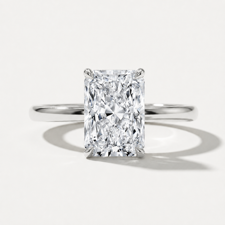 A radiant cut diamond engagement ring with a polished white gold band, centered on a clean white background with soft shadows.