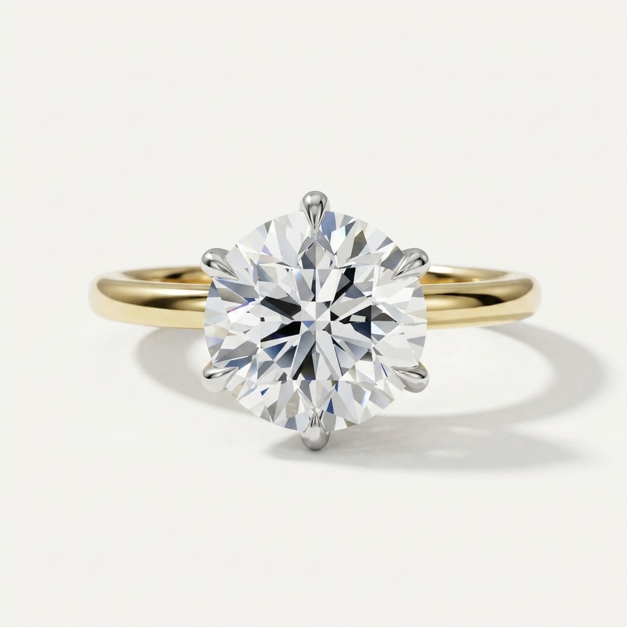 A classic solitaire engagement ring featuring a round brilliant-cut diamond set in a yellow gold four-prong band, photographed on a clean off-white background.
