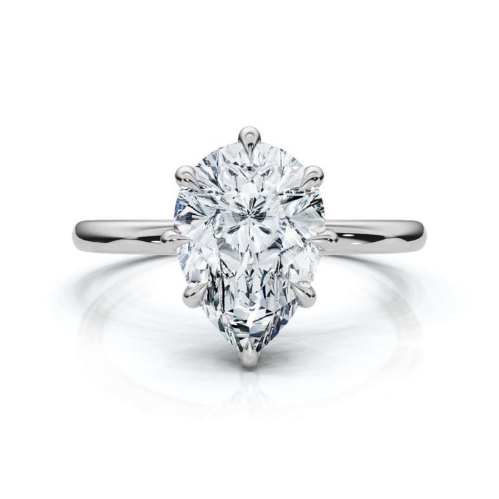 Timeless classic pear solitaire diamond ring, featuring a stunning pear-shaped center diamond set in a sleek four-prong setting, offering an elegant and sophisticated design perfect for engagements or special occasions.