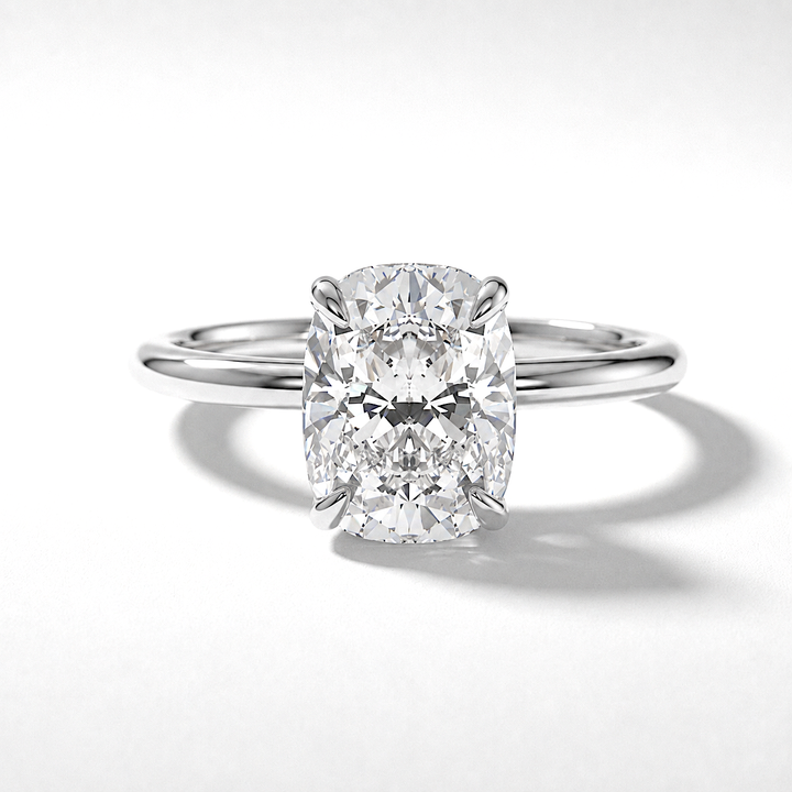 Elongated cushion diamond solitaire engagement ring with a hidden halo