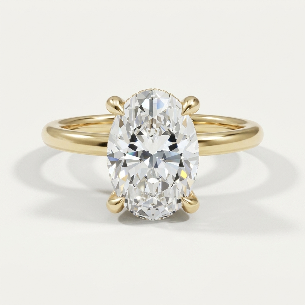An oval-cut diamond engagement ring with diamond hidden halo in a yellow gold band with a four-prong setting, shown on a clean off-white background.