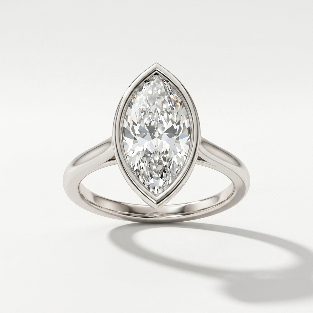 A white gold diamond ring featuring a marquise-cut diamond center stone in a bezel setting, shown on a clean white background with a soft shadow.