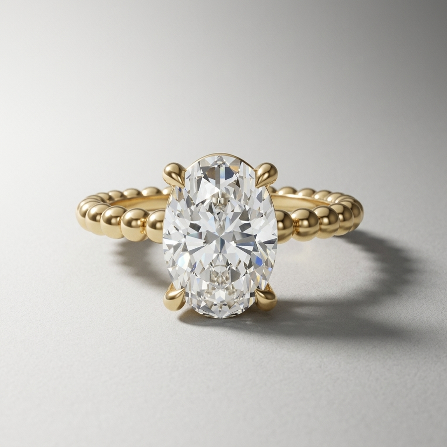 Oval diamond solitaire engagement ring on a beaded gold band