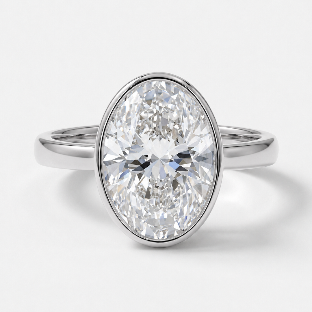An oval-cut diamond engagement ring with a polished white gold band, shown on a clean white background.