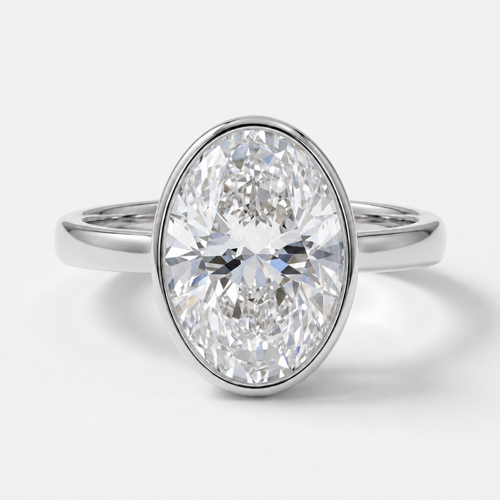 An oval-cut diamond engagement ring with a polished white gold band, shown on a clean white background.