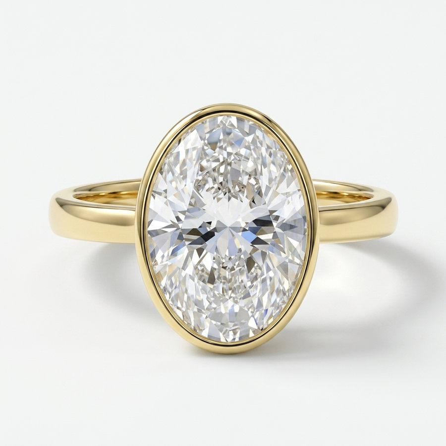 A yellow gold ring featuring a large oval-cut diamond in a bezel setting, shown on a clean white background.