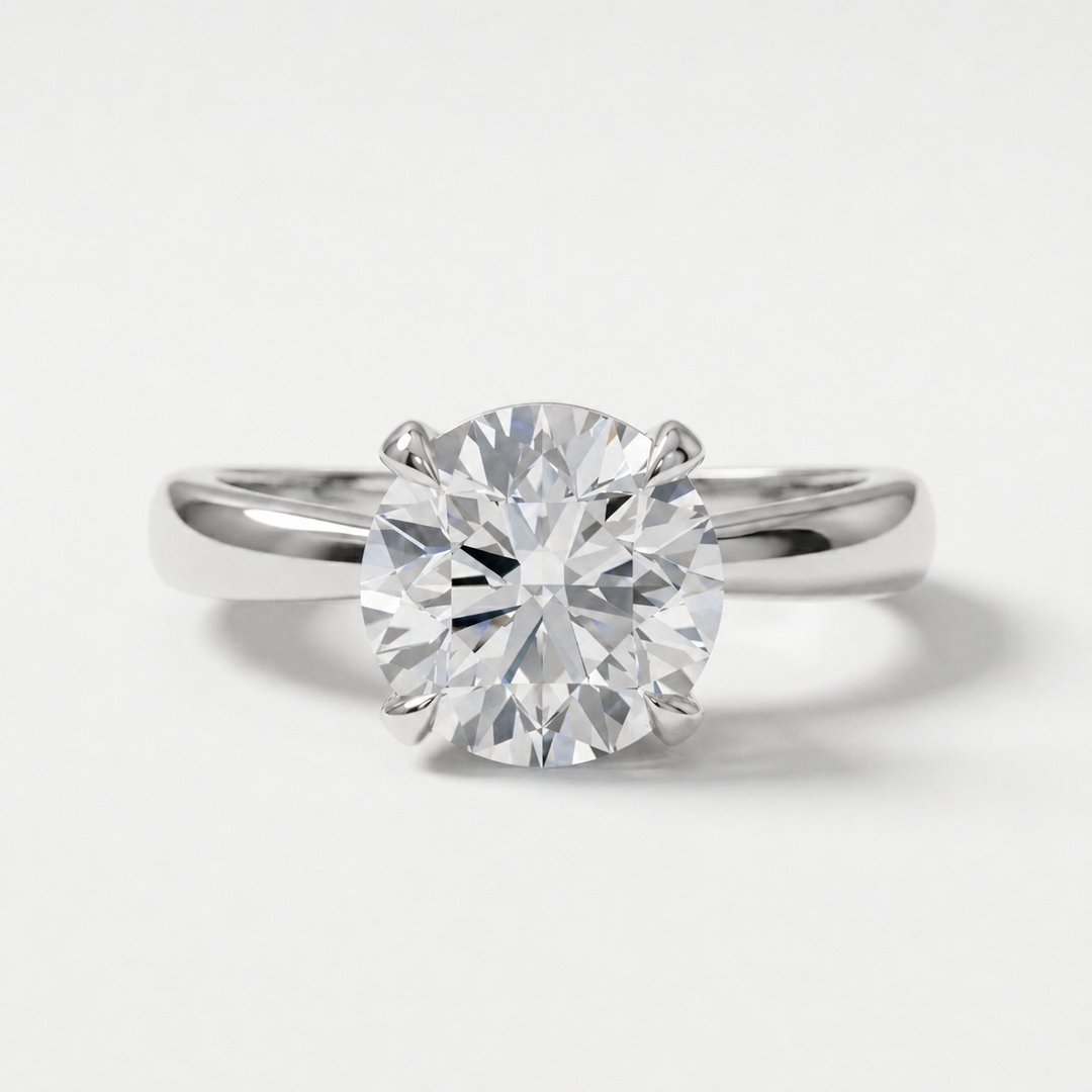 A classic solitaire engagement ring featuring a round brilliant-cut diamond set in a polished white gold metal band, shown against a clean white background.