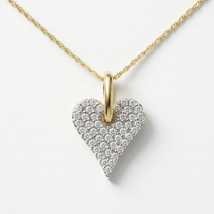 A gold heart pendant necklace featuring a pavé-set heart-shaped cluster of clear stones, suspended from a delicate gold chain on a clean white background.