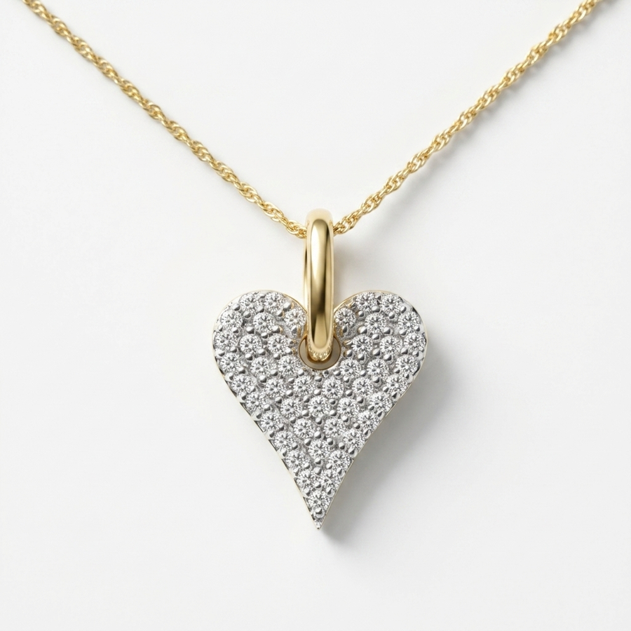 A gold heart pendant necklace featuring a pavé-set heart-shaped cluster of clear stones, suspended from a delicate gold chain on a clean white background.