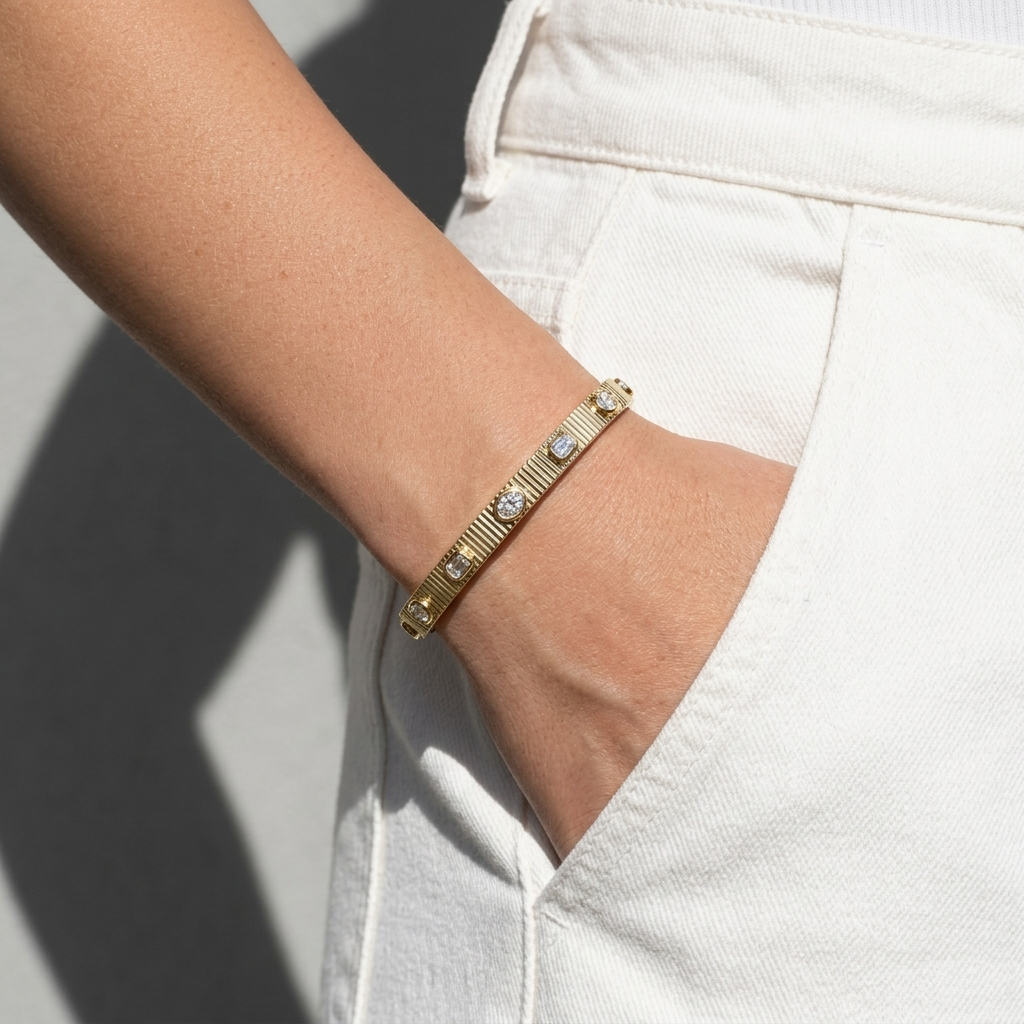 Refined 3.85ctw oval-cut lab grown emerald and diamond bangle in yellow gold, a sleek and sophisticated accessory for any occasion
