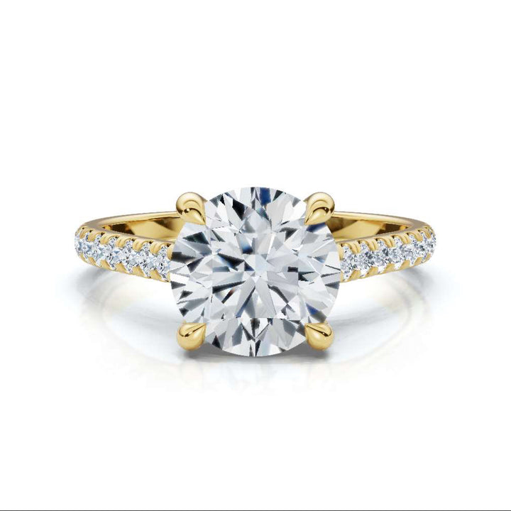 Gold ring with a large diamond and smaller diamonds on the band against a white background